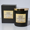 Aquarius zodiac candle with cherry blossom scent in front of its packaging on a light gray background