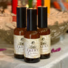 Three bottles of 'Faery Queen' ritual spray on a surface with a blurred background.