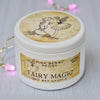 Candle jar labeled 'Fairy Magic' with fairy design on a light background