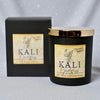 Black candle with gold lid and 'Kali Goddess' label next to a black box with the same branding on a gray background.