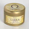 A gold metal tin candle labeled 'Libra Peony' with a textured beige label and a Libra zodiac symbol printed on the lid, set against a plain light gray background.