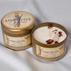 Aphrodite-themed candle in a tin with decorative elements on a light gray background