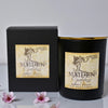 Black candle with 'Maiden Godless' label and packaging on a light background