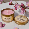 Pink candle in a gold tin with 'Maiden Goddess' branding, surrounded by cherry blossoms.