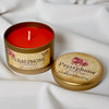 Persephone Goddess candle in a tin with a pomegranate design on a white fabric background